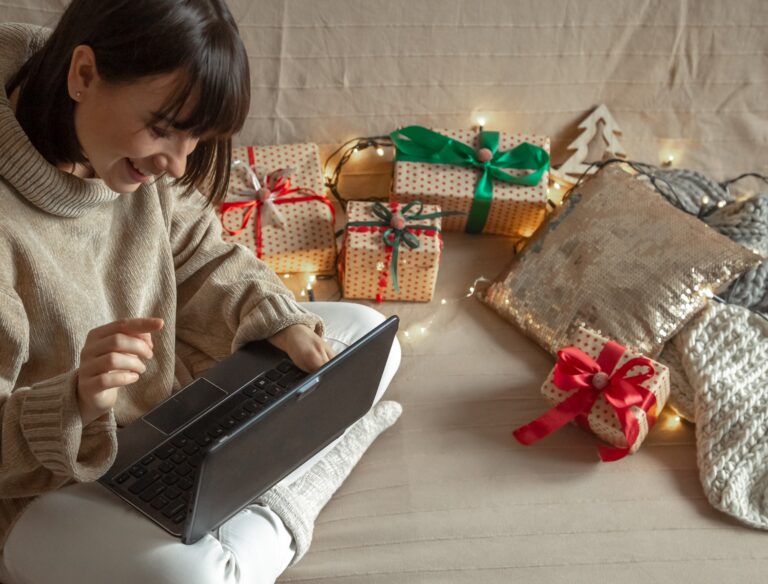 Woman at laptop buys christmas gifts online on the internet at home.